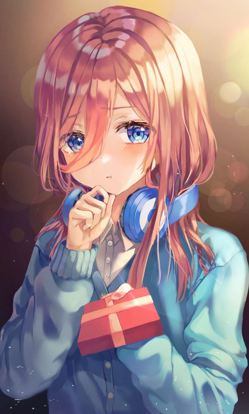 1girl absurdres bangs blue_eyes blue_sweater blush brown_background brown_hair buttons collared_shirt commentary eyebrows_visible_through_hair eyes_visible_through_hair gift go-toubun_no_hanayome hair_between_eyes hand_on_own_chin hands_up headphones headphones_around_neck highres holding holding_gift huge_filesize lime1125 long_hair long_sleeves looking_away nakano_miku pink_nails pout shirt sidelocks solo sweater tears white_shirt