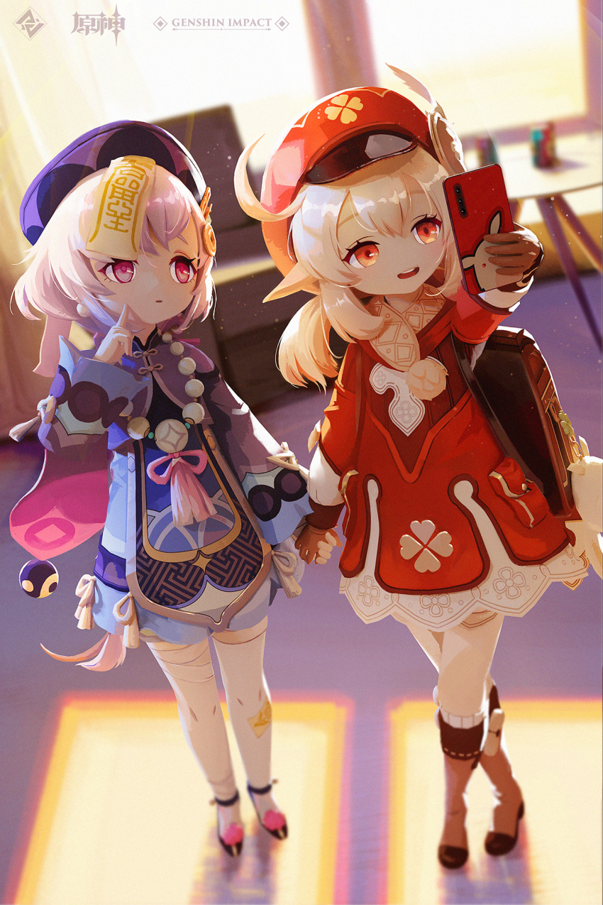 2girls ahoge arm_up backpack bag bag_charm bandaged_leg bandages bangs bead_necklace beads blurry boots bow brown_footwear brown_gloves brown_scarf cabbie_hat cape cellphone charm_(object) clover_print coat coin_hair_ornament commentary_request depth_of_field dodoco_(genshin_impact) earrings eyebrows_visible_through_hair finger_to_cheek full_body genshin_impact gloves hair_between_eyes hair_bow hair_ribbon hat hat_feather hat_ornament head_tilt highres holding holding_hands holding_phone jewelry jiangshi klee_(genshin_impact) knee_boots kneehighs light_brown_hair long_hair long_sleeves looking_away low_twintails multiple_girls necklace ofuda orange_eyes parted_lips pdy phone pocket pointy_ears purple_hair qing_guanmao qiqi_(genshin_impact) randoseru red_coat red_headwear ribbon scarf shade sidelocks smartphone standing thigh-highs twilight twintails violet_eyes white_legwear wide_sleeves window zettai_ryouiki