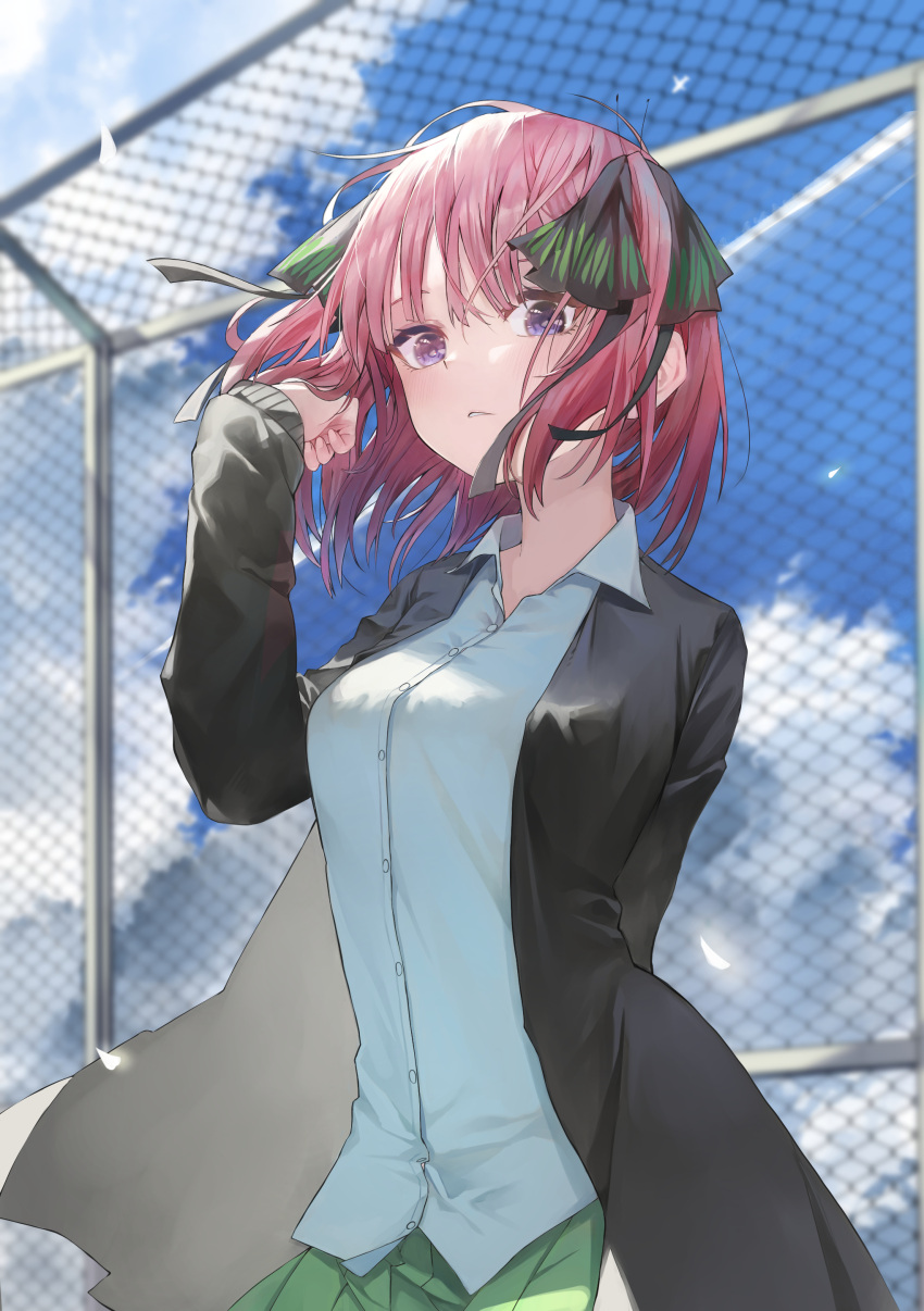 1girl absurdres arm_behind_back arm_up bangs black_cardigan blue_eyes blurry blurry_background blush bow breasts cardigan chain-link_fence clouds cloudy_sky collared_shirt eyebrows_behind_hair fence fudepenbrushpen go-toubun_no_hanayome green_bow hair_ribbon hand_in_hair highres looking_at_viewer nakano_nino open_cardigan open_clothes outdoors parted_lips pink_hair ribbon school_uniform shirt short_hair sky solo white_shirt wind wind_lift