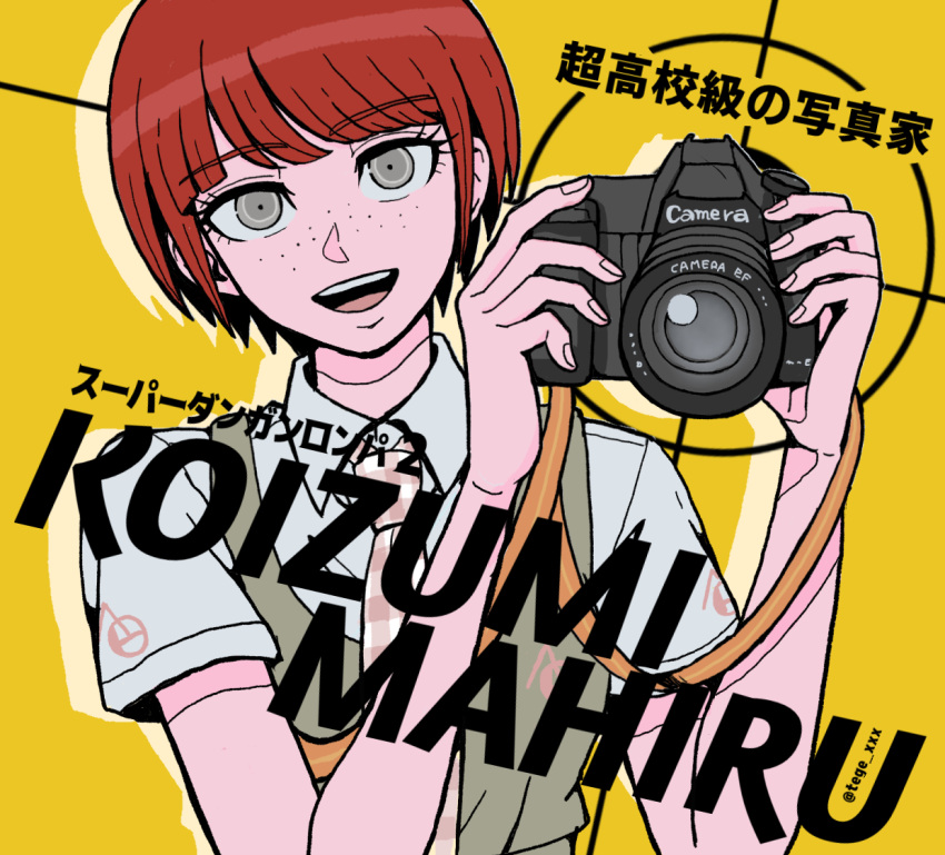 1girl :d bangs bob_cut camera character_name collared_shirt commentary_request copyright_name dangan_ronpa_(series) dangan_ronpa_2:_goodbye_despair dress eyebrows_visible_through_hair freckles hands_up holding holding_camera koizumi_mahiru looking_at_viewer necktie open_mouth pinafore_dress plaid_neckwear redhead shirt short_hair short_sleeves simple_background smile solo tege_(tege_xxx) translation_request twitter_username upper_body upper_teeth yellow_background
