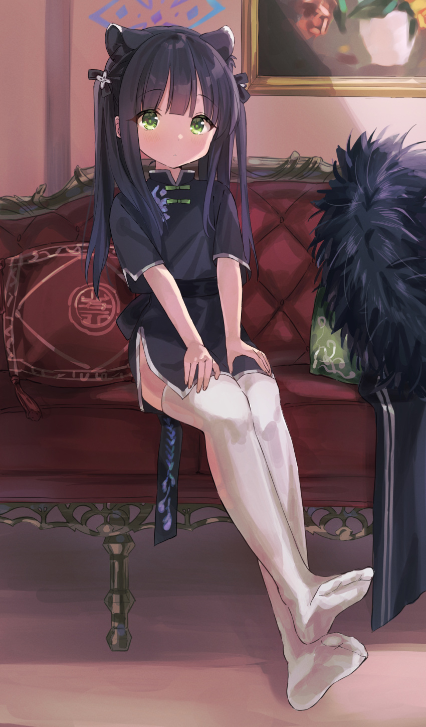 1girl animal_ears black_hair blue_archive blush chinese_clothes couch full_body green_eyes highres long_hair looking_at_viewer no_shoes painting ponpon_nun shun_(blue_archive) sitting solo thigh-highs twintails white_legwear younger