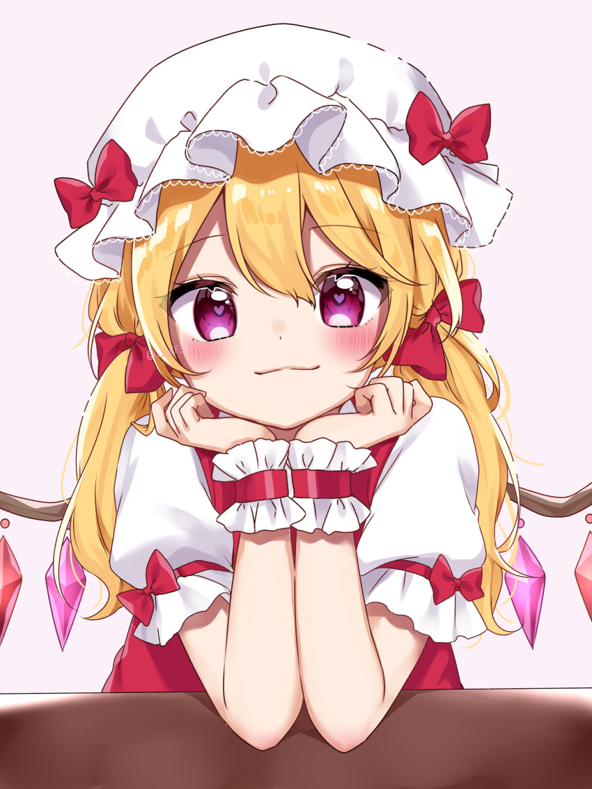 1girl :3 absurdres alternate_eye_color blonde_hair blush bow crystal elbows_on_table eyebrows_visible_through_hair flandre_scarlet hair_between_eyes hair_ribbon hat hat_bow hat_ribbon heart heart-shaped_pupils highres long_hair looking_at_viewer mob_cap pink_background puffy_short_sleeves puffy_sleeves red_ribbon red_vest ribbon shiki_(s1k1xxx) shirt short_sleeves side_ponytail smile solo symbol-shaped_pupils table touhou twitter_username vest violet_eyes white_shirt wings wrist_ribbon
