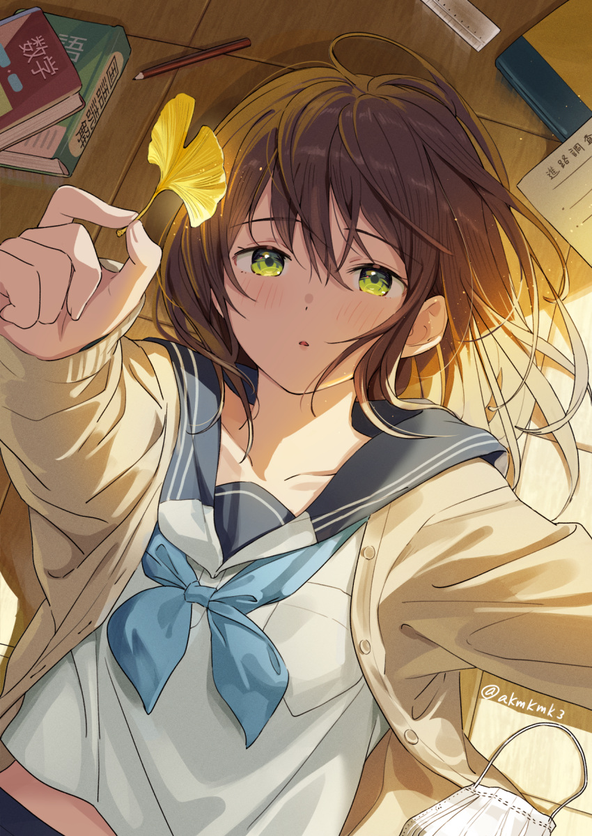 1girl akamoku bangs blue_neckwear blue_sailor_collar blush book brown_cardigan brown_hair buttons cardigan collarbone commentary_request eyebrows_visible_through_hair ginkgo_leaf green_eyes hair_between_eyes highres holding holding_leaf leaf light_particles long_hair long_sleeves lying midriff_peek neckerchief on_back original outstretched_arm parted_lips pencil ruler sailor_collar school_uniform serafuku shirt solo translation_request twitter_username upper_body white_shirt