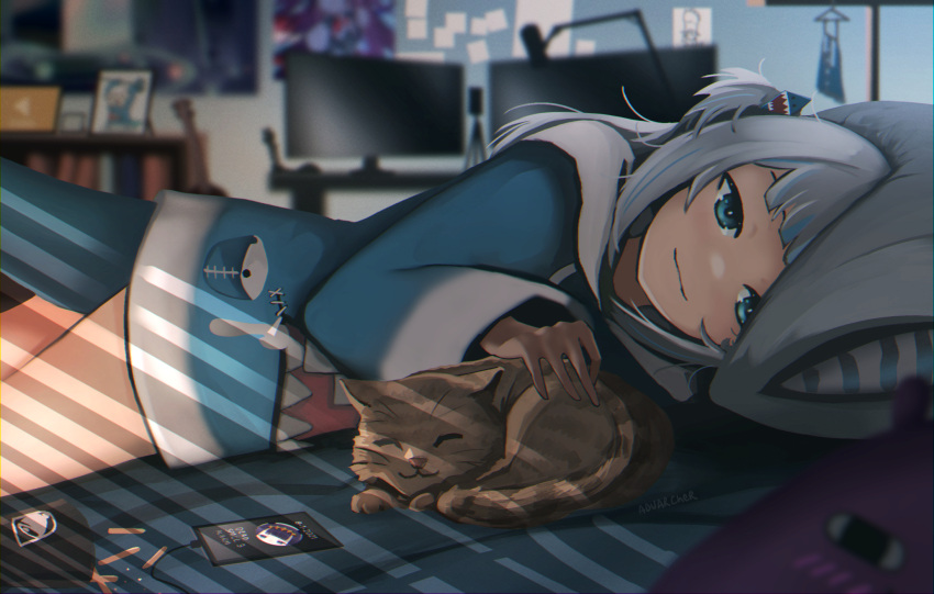 1girl animal_costume animal_hood anonamos artist_name bangs bed bed_sheet bedroom blue_eyes blue_hoodie blunt_bangs blurry blurry_background brown_cat cat cellphone fish_tail gawr_gura hair_ornament highres hololive hololive_english holomyth hood hoodie indoors long_sleeves looking_at_viewer lying medium_hair microphone monitor multicolored_hair on_stomach petting phone pillow shark_costume shark_girl shark_hair_ornament shark_hood shark_tail silver_hair smile streaked_hair tail virtual_youtuber