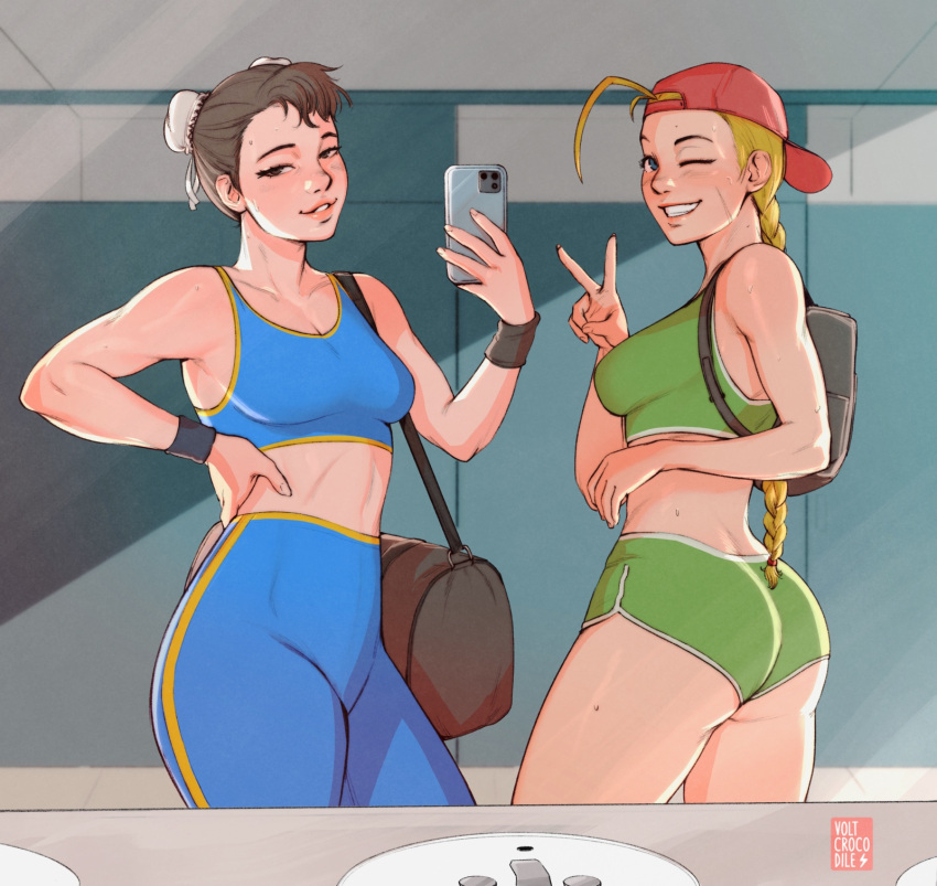 2girls ;d adapted_costume alternate_hairstyle antenna_hair ass backpack backwards_hat bag baseball_cap blue_eyes blue_pants blue_sports_bra braid breasts brown_eyes brown_hair bun_cover cammy_white cellphone chun-li dolphin_shorts double_bun duffel_bag english_commentary fingernails green_shorts green_sports_bra grin gym hair_pulled_back hair_through_headwear hat highres holding holding_phone light_smile lips long_braid long_hair medium_breasts midriff mirror_image multiple_girls nose one_eye_closed open_mouth pants phone red_headwear short_hair shorts single_braid sink smartphone smile sports_bra stomach street_fighter street_fighter_zero_(series) sweat taking_picture thighs toned twisted_torso volt_crocodile wristband yoga_pants