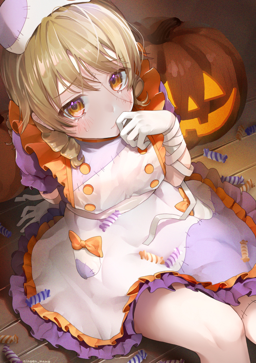 1girl absurdres apron artist_name bandaged_arm bandages blonde_hair blush bow brown_eyes candy commentary_request dress drill_hair finger_to_mouth food frilled_apron frills hair_between_eyes halloween halloween_costume highres idolmaster idolmaster_cinderella_girls jack-o'-lantern medium_hair morikubo_nono ningen_mame orange_bow pumpkin purple_dress short_sleeves sitting solo stitched_face stitched_leg stitches tears white_apron white_headwear