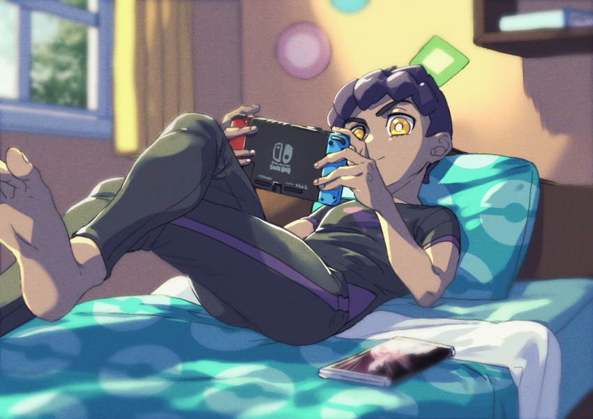 1boy barefoot black_pants black_shirt bright_pupils closed_mouth crossed_legs curtains dark-skinned_male dark_skin handheld_game_console highres holding holding_handheld_game_console hop_(pokemon) indoors komame_(st_beans) lying male_focus nintendo_switch on_back on_bed pants pillow playing_games poke_ball_print pokemon pokemon_(game) pokemon_swsh purple_hair shelf shirt short_hair short_sleeves smile soles solo symbol-only_commentary t-shirt toes white_pupils window yellow_eyes