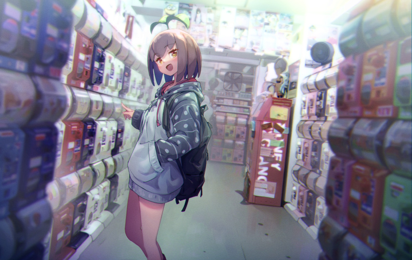 1girl atm backpack bag blurry brown_hair commentary_request depth_of_field despicable_me electric_fan eva_mashiro eva_mashiro_(vtuber) feet_out_of_frame gashapon_machine grey_hoodie hand_in_pocket head_tilt highres hood hood_down hoodie indoors long_sleeves looking_at_viewer minion_(despicable_me) open_mouth original pointing short_hair smile solo sprout standing virtual_youtuber yellow_eyes