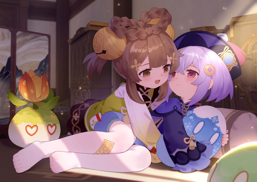 2girls :d bangs bell brown_eyes brown_hair coin_hair_ornament commentary_request genshin_impact hair_bell hair_between_eyes hair_ornament hair_rings hat highres indoors jingle_bell long_sleeves looking_at_another multiple_girls no_shoes ofuda open_mouth pantyhose purple_hair qing_guanmao qiqi_(genshin_impact) red_eyes smile tsubasa_tsubasa white_legwear wide_sleeves yaoyao_(genshin_impact) yuri
