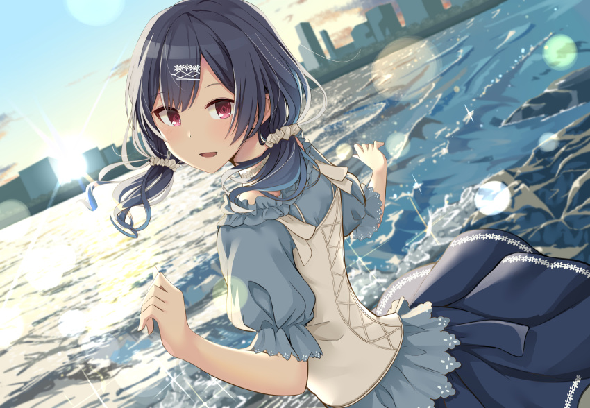 1girl :d bangs black_hair blue_shirt blue_skirt cac_itinose commentary_request dutch_angle eyebrows_visible_through_hair hair_ornament hair_scrunchie hairclip hands_up highres idolmaster idolmaster_shiny_colors lake long_hair looking_at_viewer looking_back low_twintails morino_rinze outdoors pleated_skirt puffy_short_sleeves puffy_sleeves red_eyes scrunchie shirt short_sleeves skirt skyline smile solo sunset twintails water white_scrunchie
