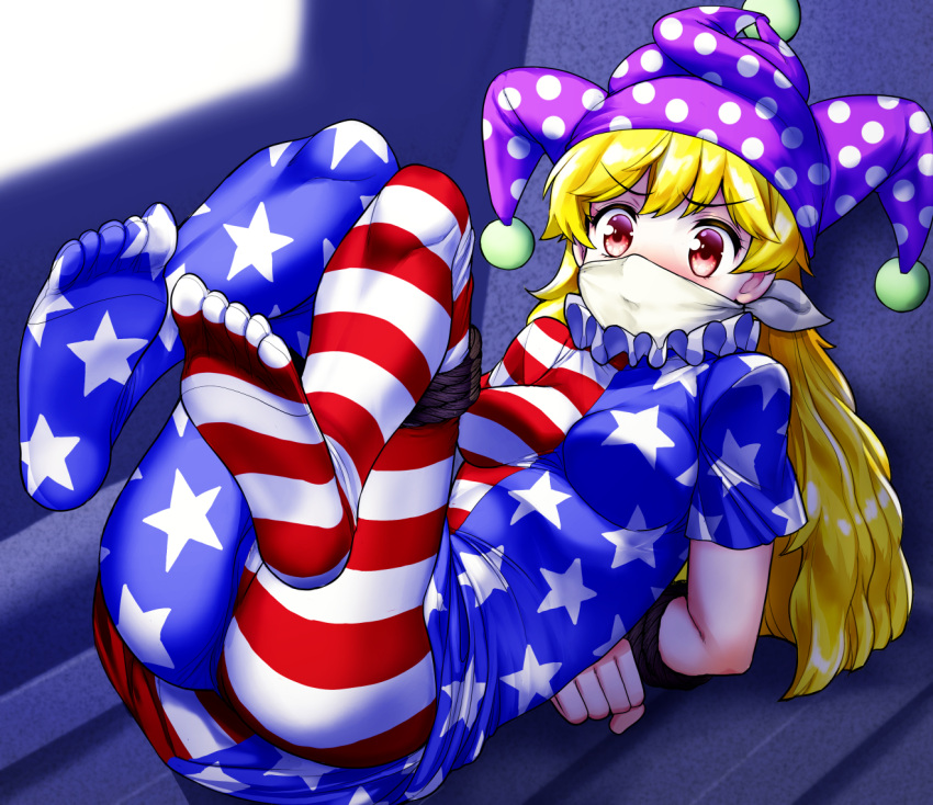 1girl american_flag_dress american_flag_legwear bangs blonde_hair blush cloth_gag clownpiece commentary_request commission eyebrows_visible_through_hair feet frilled_shirt_collar frills furrowed_brow gag gagged hat improvised_gag jester_cap long_hair lying mono_(moiky) neck_ruff no_shoes on_back over_the_nose_gag pantyhose polka_dot red_eyes restrained skeb_commission soles solo touhou