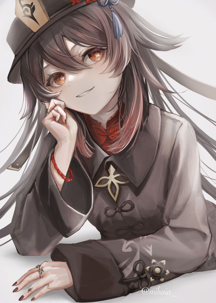 1girl absurdres arm_support black_headwear black_jacket black_nails bracelet brown_hair chinese_clothes commentary eyelashes flat_chest flower flower-shaped_pupils flower_knot genshin_impact grey_background grin hair_between_eyes hand_on_own_face hat hat_flower highres hu_tao_(genshin_impact) jacket jewelry long_hair long_sleeves looking_at_viewer lying mihaia multicolored_hair multiple_rings nail_polish on_stomach parted_lips porkpie_hat red_eyes red_shirt redhead ring shirt simple_background smile solo symbol-shaped_pupils tangzhuang tassel twitter_username two-tone_hair upper_body
