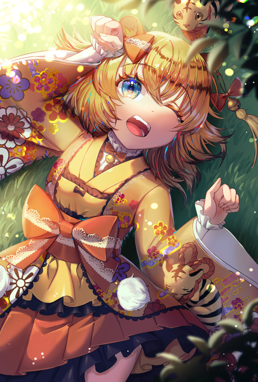 1girl animal_ears bangs bell blurry bokeh bow child chinese_zodiac commentary_request depth_of_field eyebrows_visible_through_hair floral_print grass grin highres japanese_clothes kimono kimono_skirt looking_at_viewer lying nengajou new_year orange_hair original raymond_busujima smile tassel tearing_up tiger tiger_ears tiger_girl year_of_the_tiger