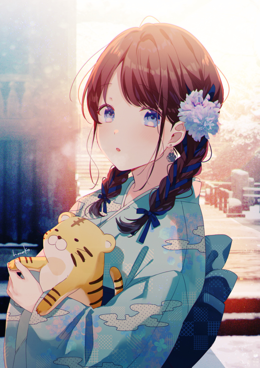 1girl :o animal bangs blue_eyes blue_flower blue_kimono blurry blurry_background blush braid braided_ponytail brown_hair earrings floral_print flower hair_flower hair_ornament hair_ribbon hanako151 highres holding holding_animal japanese_clothes jewelry kanzashi kimono long_hair looking_at_viewer new_year obi original parted_lips ribbon sash solo tiger twintails