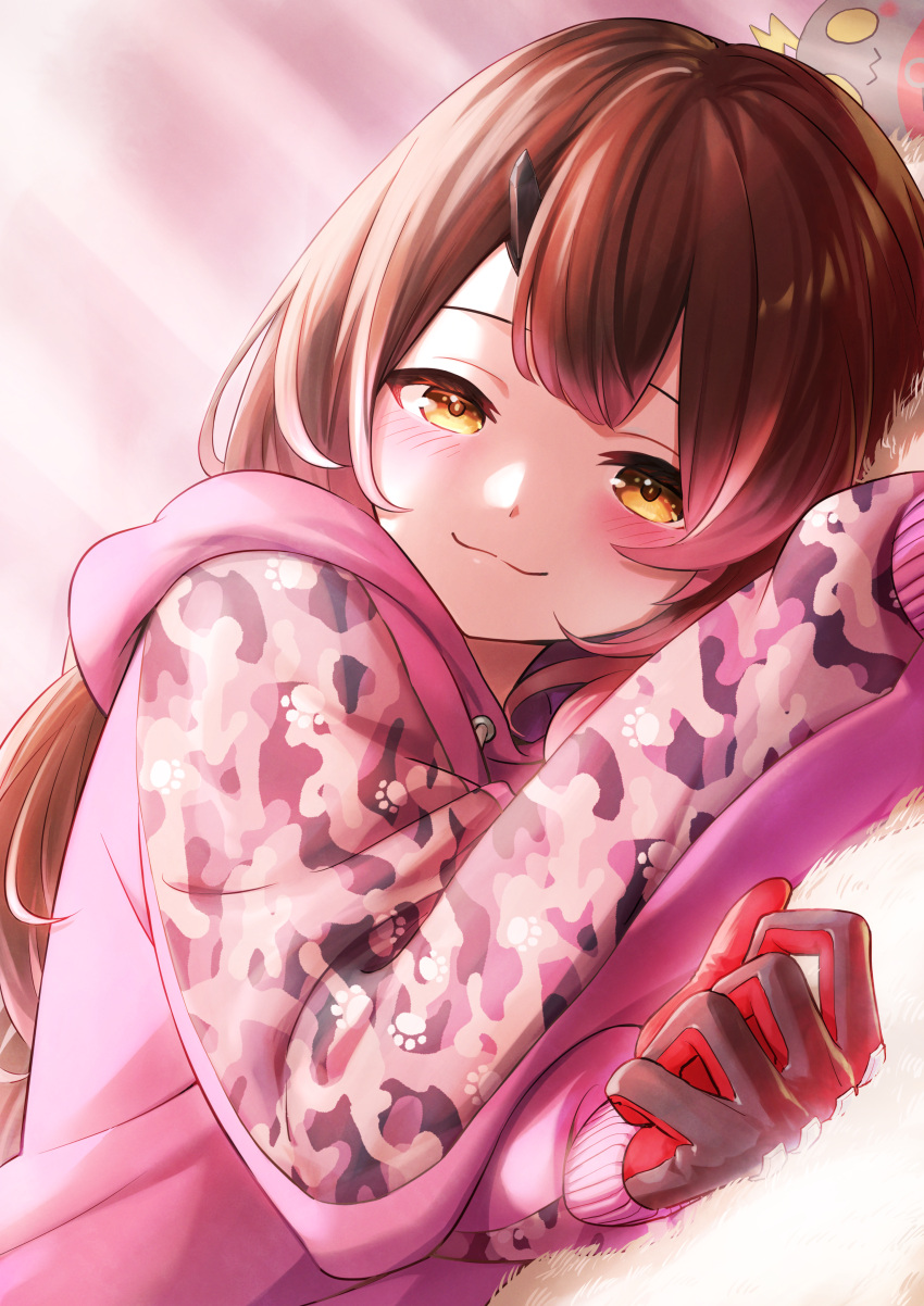 1girl :3 absurdres bangs black_gloves blush brown_eyes brown_hair camouflage closed_mouth commentary_request dutch_angle gloves highres hololive hood hoodie long_hair long_sleeves looking_at_viewer lying nemoto_yuuma on_side pink_hoodie roboco-san solo upper_body virtual_youtuber