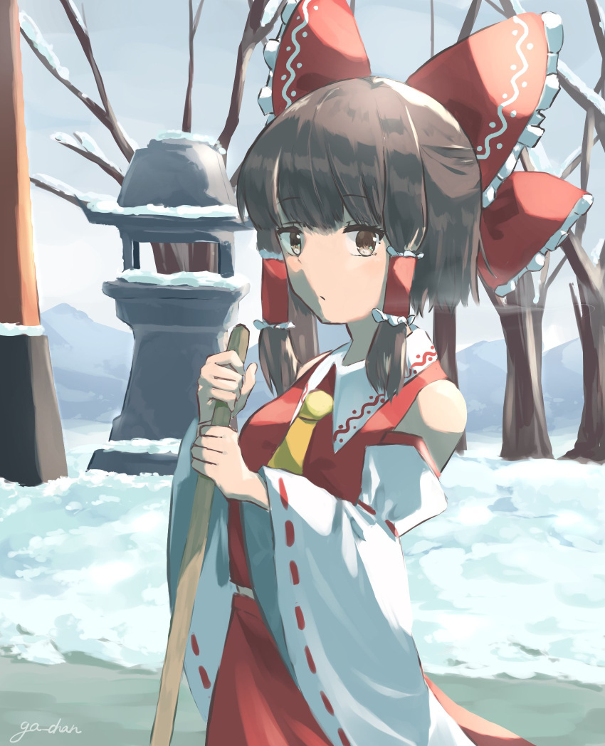1girl ascot bare_shoulders bare_tree bow broom brown_eyes brown_hair collar detached_sleeves eyebrows_visible_through_hair ga-chan24 hair_bow hair_tubes hakurei_reimu hakurei_shrine highres japanese_clothes looking_to_the_side miko nontraditional_miko outdoors red_bow red_shirt red_skirt ribbon-trimmed_sleeves ribbon_trim shirt short_hair sidelocks skirt skirt_set sleeveless snow solo sweeping touhou tree white_collar wide_sleeves winter yellow_ascot