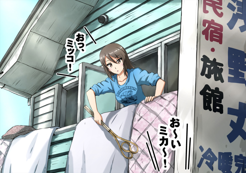 1girl bangs blue_shirt brown_eyes brown_hair building casual clothes_writing commentary day eyebrows_visible_through_hair futon_tataki girls_und_panzer highres holding long_hair long_sleeves looking_at_viewer mika_(girls_und_panzer) no_hat no_headwear omachi_(slabco) ooarai_(ibaraki) open_mouth outdoors print_shirt romaji_text shirt sign sleeves_rolled_up solo translated
