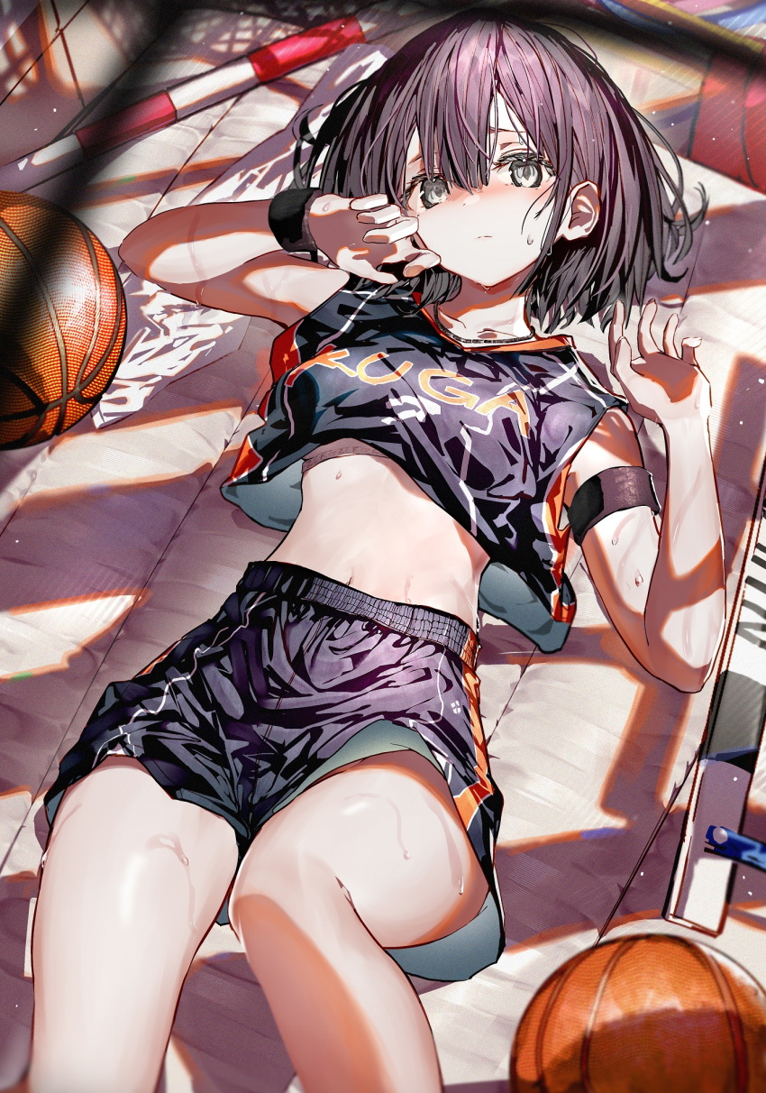 1girl armlet bangs basketball basketball_uniform black_hair breasts closed_mouth commentary_request cowboy_shot day enj! from_above grey_eyes hair_between_eyes highres looking_at_viewer lying medium_breasts midriff navel on_back original short_hair solo sportswear sunlight sweat thighs upshorts wiping_sweat