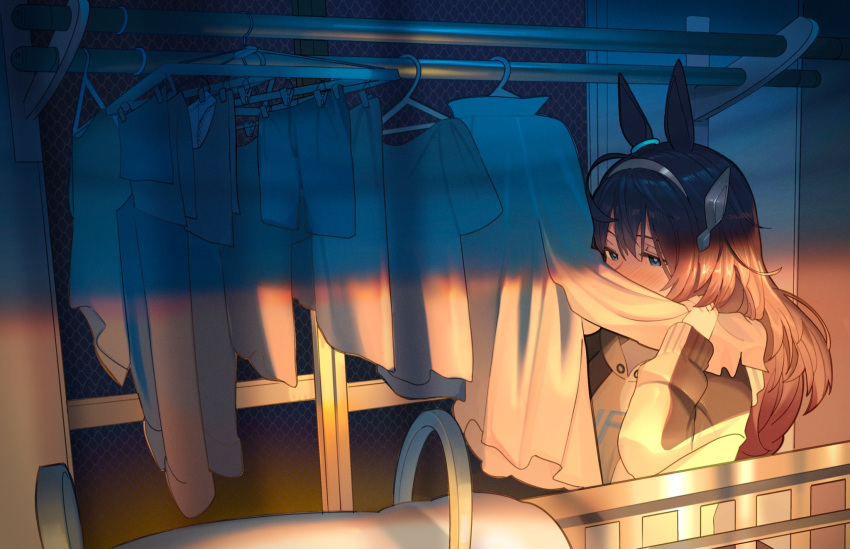 1girl ahoge animal_ears ashinowoto bangs blue_eyes blush brown_hair clothes_hanger headband highres hood hoodie horse_ears laundry long_hair long_sleeves mihono_bourbon_(umamusume) shirt_tucked_in shorts smelling smelling_clothes solo sunset umamusume underwear upper_body