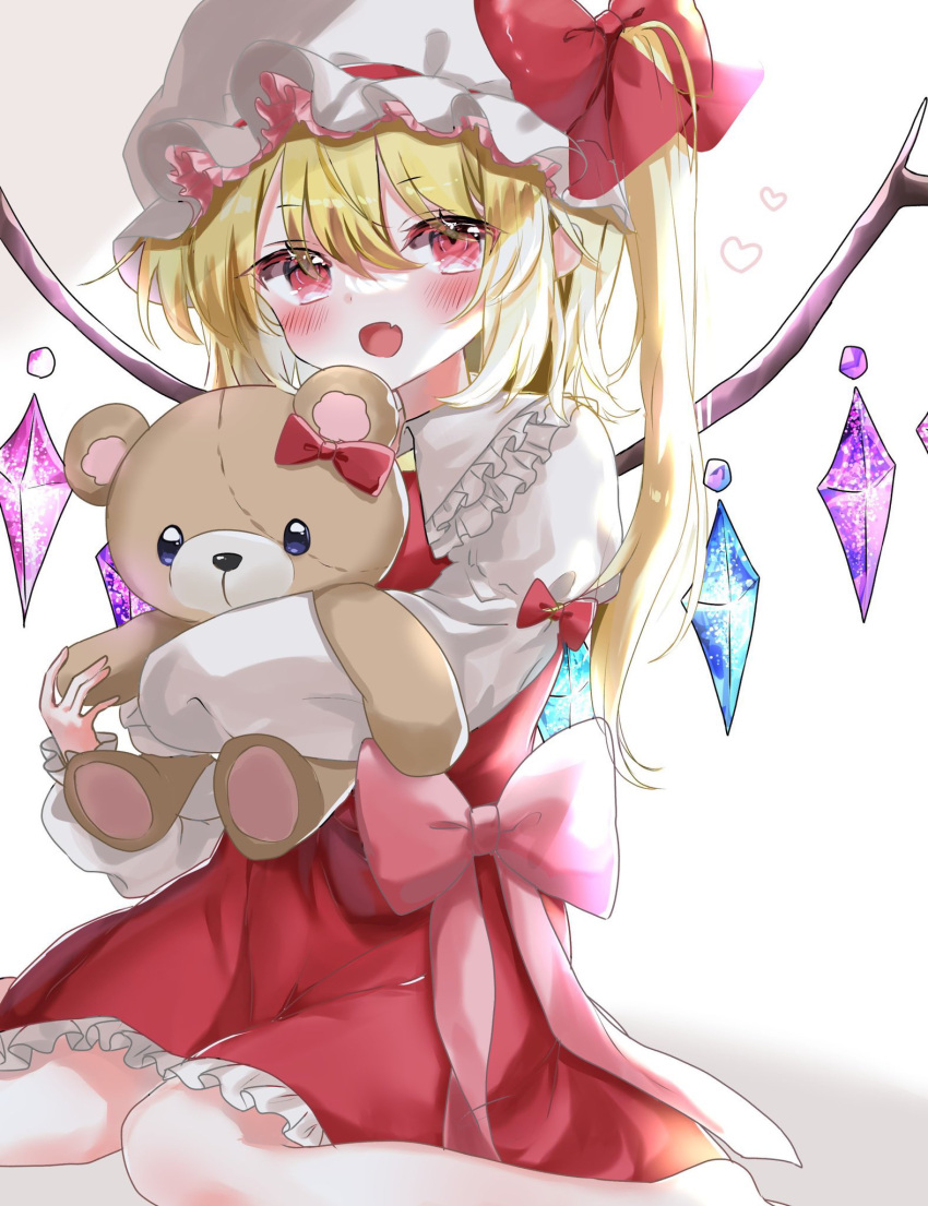 1girl blonde_hair blush bow crystal eyebrows_visible_through_hair fang flandre_scarlet hair_between_eyes happy hat hat_bow heart highres holding holding_stuffed_toy long_hair looking_at_viewer mob_cap open_mouth petticoat pointy_ears puffy_sleeves red_bow red_eyes red_skirt red_vest shinonome_(ichigotsuki) shirt sitting skin_fang skirt solo stuffed_animal stuffed_toy teddy_bear touhou vest wariza white_headwear white_shirt wings