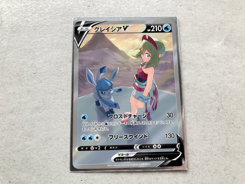 1girl anklet bangs blonde_hair blue_eyes bracelet card card_(medium) character_name character_print closed_mouth commentary_request eyelashes glaceon hairband highres irida_(pokemon) jewelry mountain official_style pokemon pokemon_(game) pokemon_legends:_arceus pokemon_tcg pokeyugami red_hairband red_shirt sash shirt shoes shorts standing strapless strapless_shirt