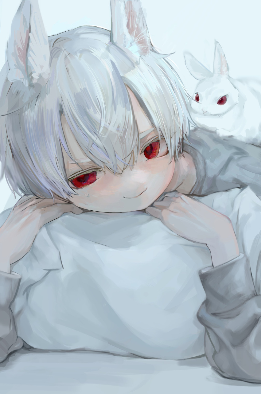 1boy absurdres animal animal_ears animal_on_back closed_mouth hair_between_eyes highres hzk_(user_kemd2843) long_sleeves looking_at_viewer lying on_stomach original pillow pillow_grab rabbit_boy red_eyes shirt short_hair smile white_background white_hair