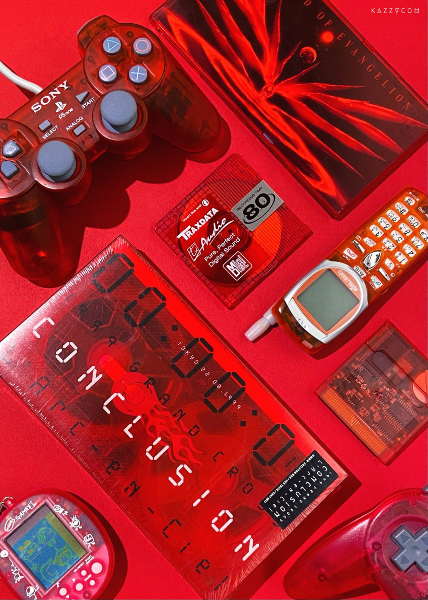 absurdres artist_name controller dualshock dvd dvd_case floppy_disk from_above game_controller gamepad highres kazzycom neon_genesis_evangelion no_humans nokia_3310 object_request original playstation_controller red_theme sony still_life