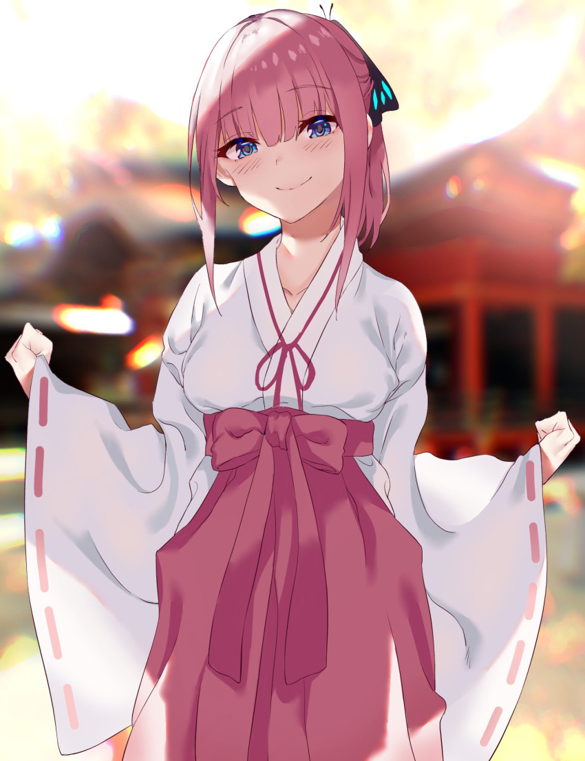 1girl alternate_hairstyle black_ribbon blue_eyes blurry blurry_background closed_mouth eyebrows_visible_through_hair go-toubun_no_hanayome hair_ribbon hakama highres japanese_clothes long_sleeves miko nakano_nino red_hakama ribbon short_hair smile solo susukida_(sususabu0710) white_sleeves wide_sleeves