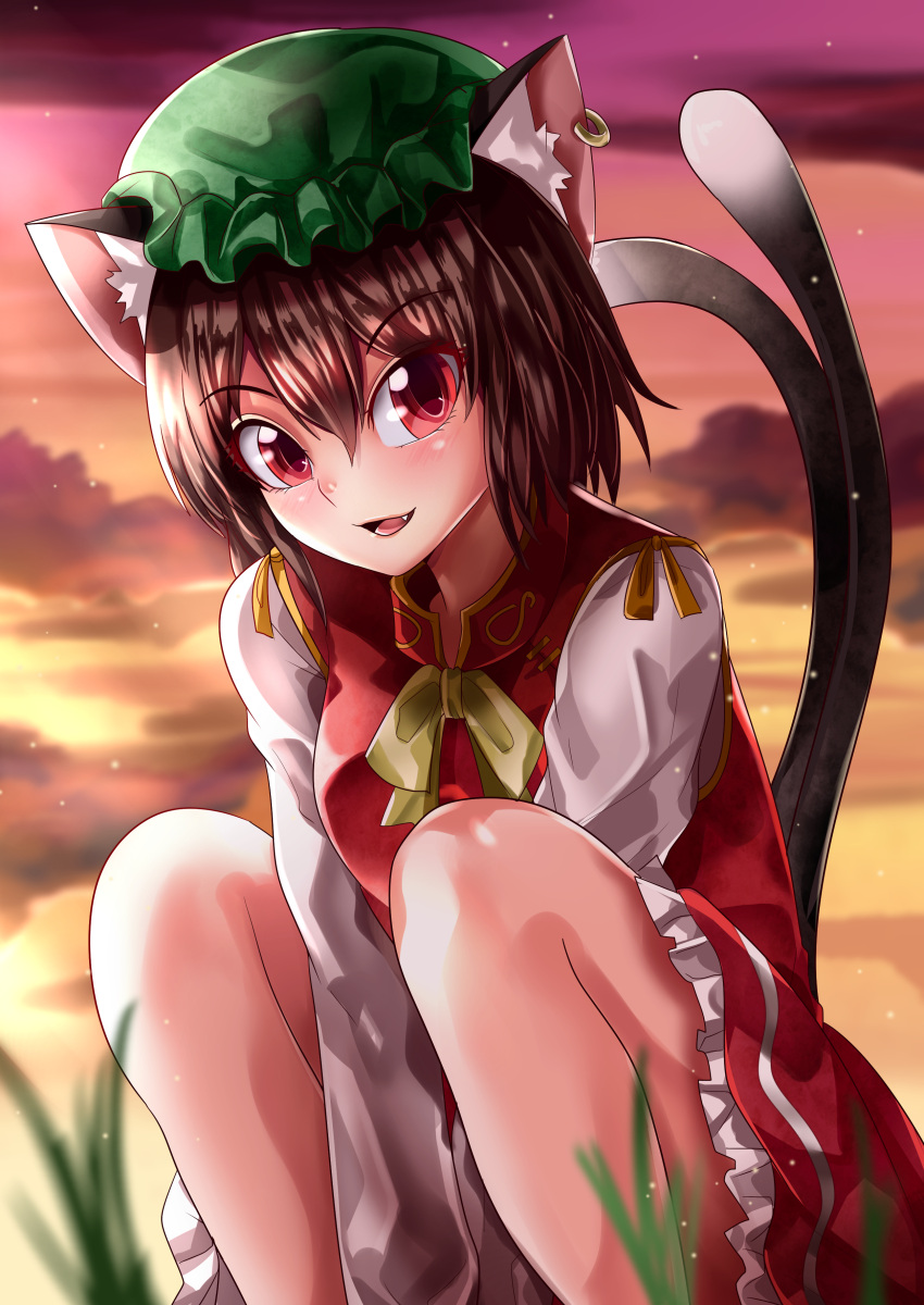 1girl absurdres animal_ear_fluff animal_ears arms_between_legs blurry blurry_foreground brown_hair cat_ears cat_tail chen clouds cloudy_sky commentary_request depth_of_field earrings eyebrows_visible_through_hair fang feet_out_of_frame frilled_skirt frills grass green_headwear hair_between_eyes hat highres jewelry long_sleeves looking_at_viewer maboroshi_mochi mob_cap multiple_tails open_mouth outdoors red_eyes red_skirt red_vest shirt short_hair single_earring skirt sky solo tail touhou twilight two_tails vest white_shirt