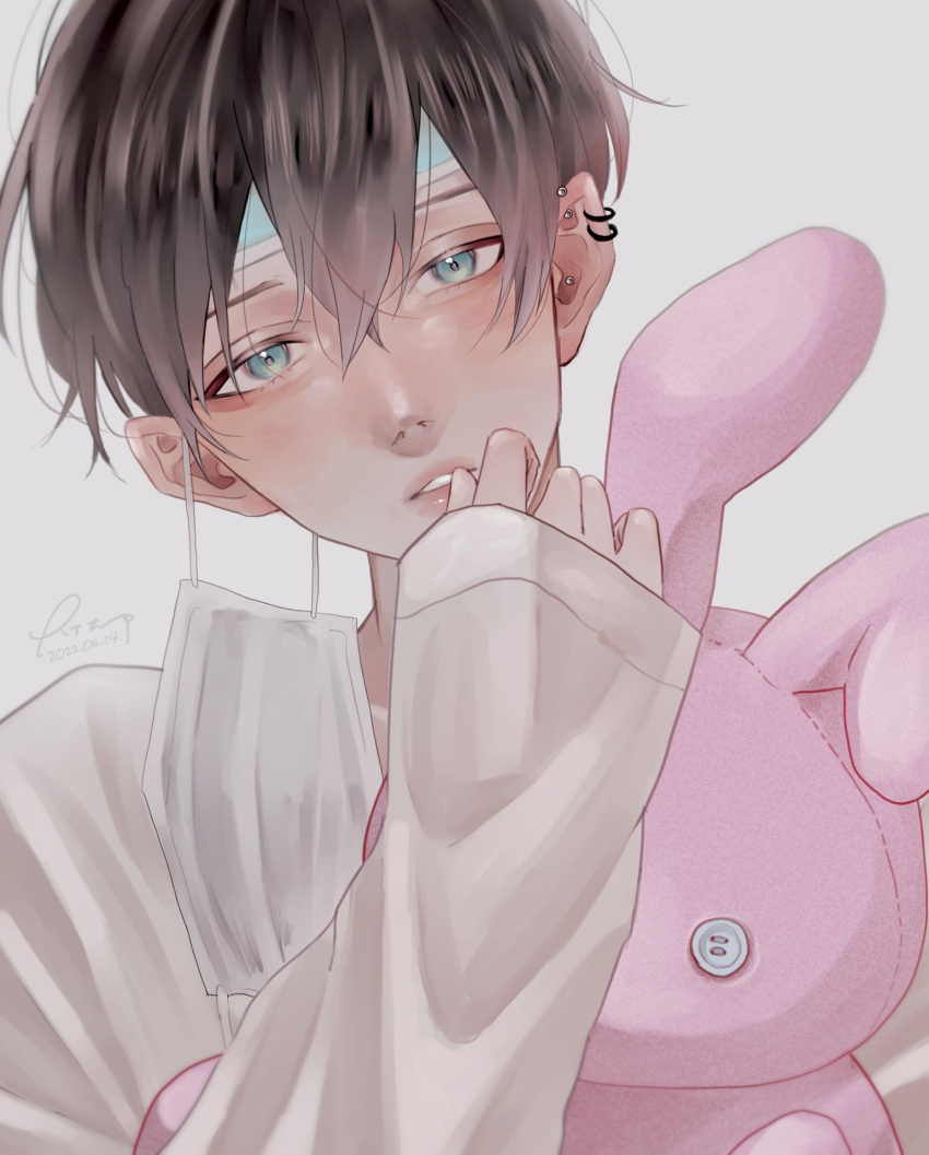 1boy blush brown_hair ear_piercing green_eyes highres long_sleeves looking_at_viewer mask mask_removed mmnkn original piercing shirt short_hair solo stuffed_animal stuffed_bunny stuffed_toy upper_body white_shirt