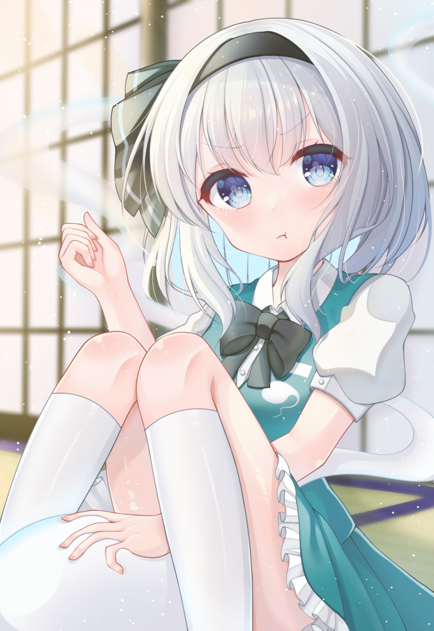 1girl :t black_bow black_bowtie black_hairband blue_eyes blurry blurry_background bow bowtie closed_mouth eyebrows_visible_through_hair ghost grey_hair hairband highres kneehighs knees_up konpaku_youmu konpaku_youmu_(ghost) looking_at_viewer myonta_(myon_myonta) pout short_hair short_sleeves sitting solo touhou white_legwear