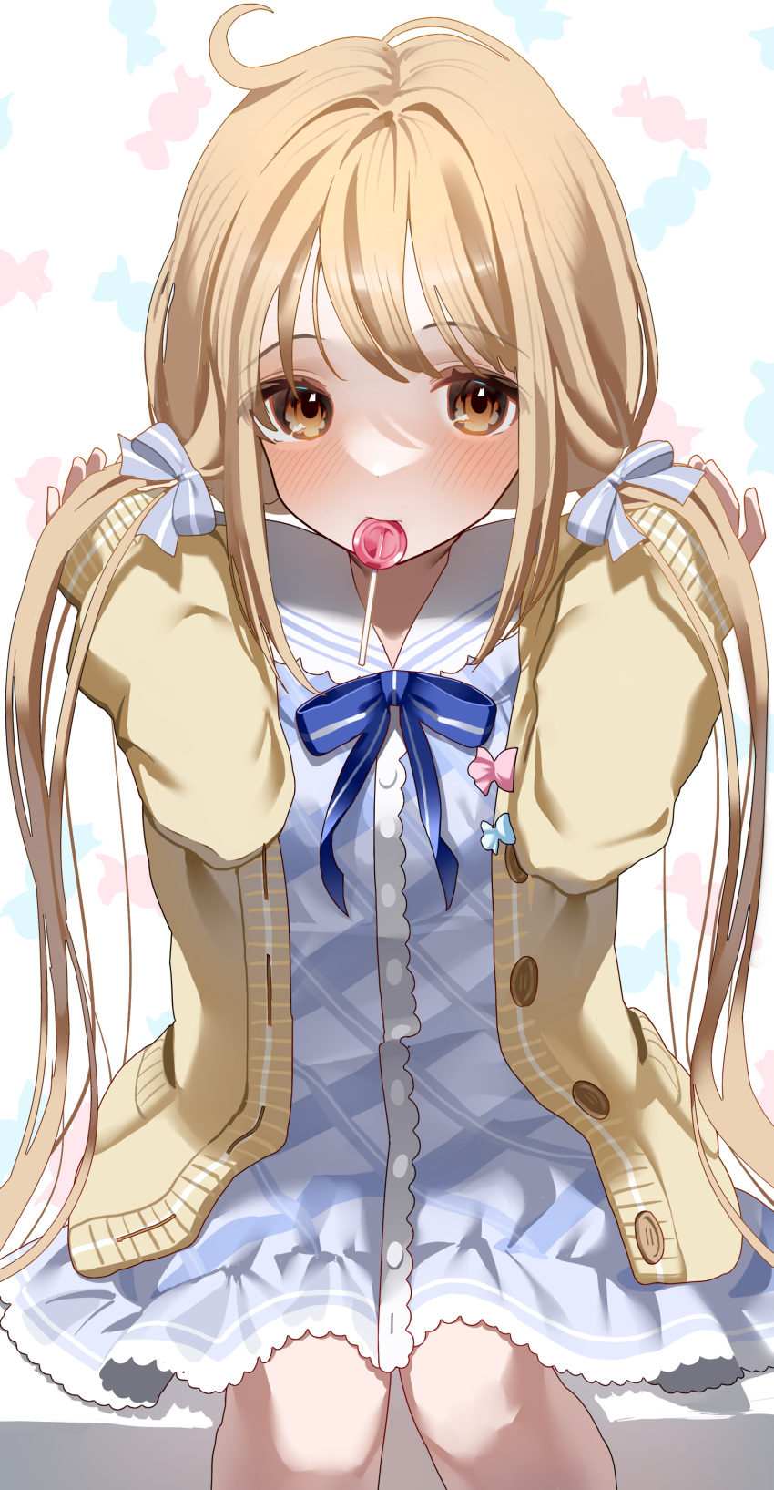 1girl absurdres blonde_hair blue_dress blush candy candy_print cardigan dress feet_out_of_frame food futaba_anzu hair_ribbon highres idolmaster idolmaster_cinderella_girls lollipop looking_at_viewer mouth_hold neck_ribbon ningen_mame ribbon sailor_collar simple_background sitting sleeves_past_wrists solo twintails yellow_cardigan