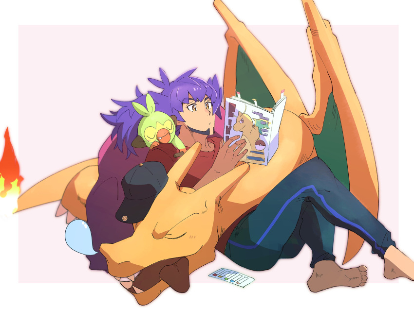 1boy barefoot black_pants border character_print charizard closed_mouth dark-skinned_male dark_skin dragonite facial_hair flame-tipped_tail grookey highres holding leon_(pokemon) long_hair magazine_(object) male_focus morio_(poke_orio) pants pokemon pokemon_(creature) pokemon_(game) pokemon_swsh purple_hair reading red_shirt shirt sitting soles t-shirt toes white_border yellow_eyes