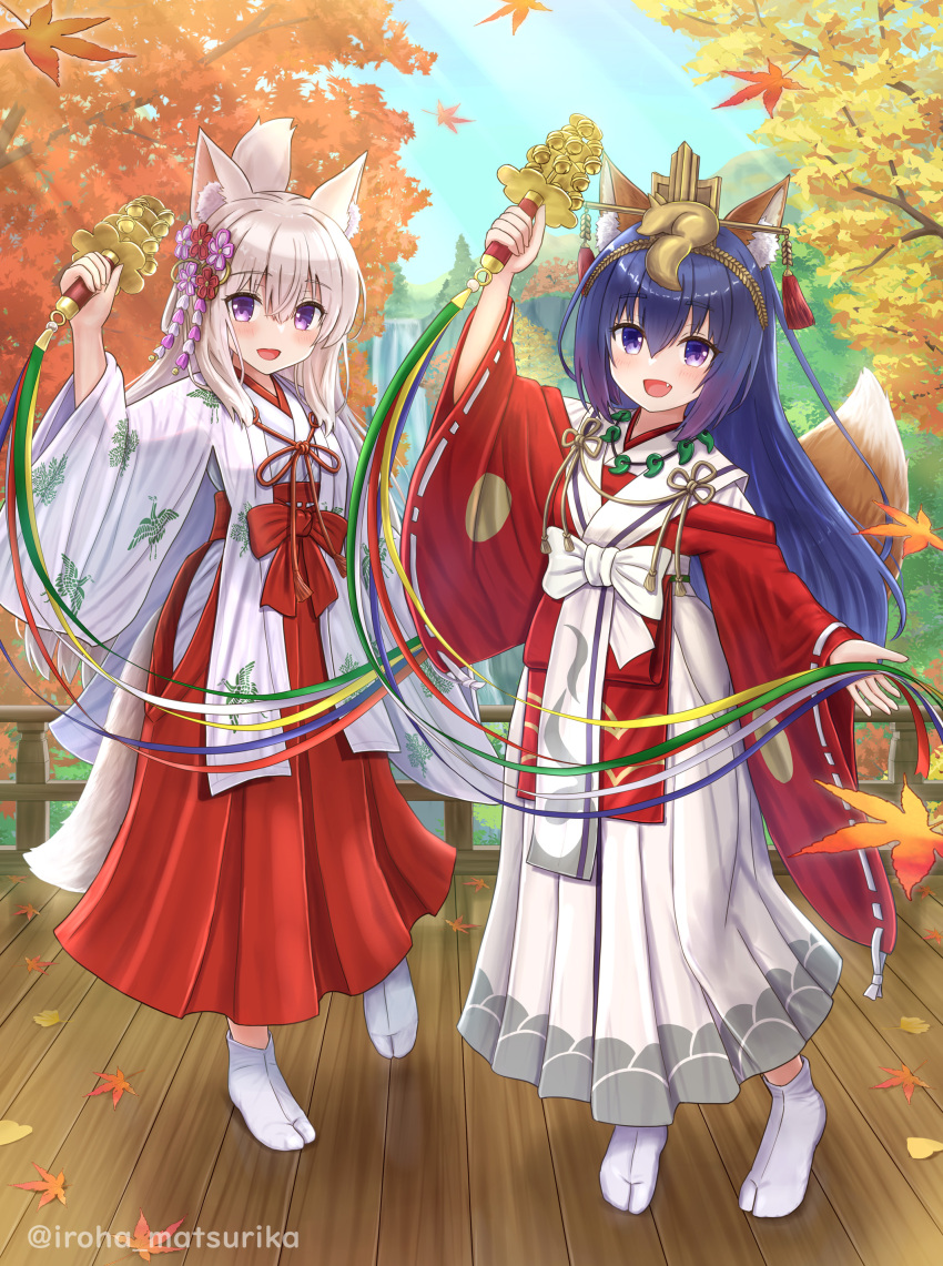 2girls :d absurdres animal_ear_fluff animal_ears arm_up autumn_leaves bangs bell blue_hair blue_sky commentary_request day fang folded_ponytail fox_ears fox_girl fox_tail grey_hair hair_between_eyes hakama hakama_skirt highres holding iroha_(iroha_matsurika) japanese_clothes jingle_bell kagura_suzu kimono koyoi_(iroha_(iroha_matsurika)) leaf long_sleeves maple_leaf miko multiple_girls no_shoes original outdoors red_hakama red_kimono ribbon-trimmed_sleeves ribbon_trim skirt sky smile socks standing standing_on_one_leg tabi tail twitter_username violet_eyes white_hakama white_kimono white_socks wide_sleeves