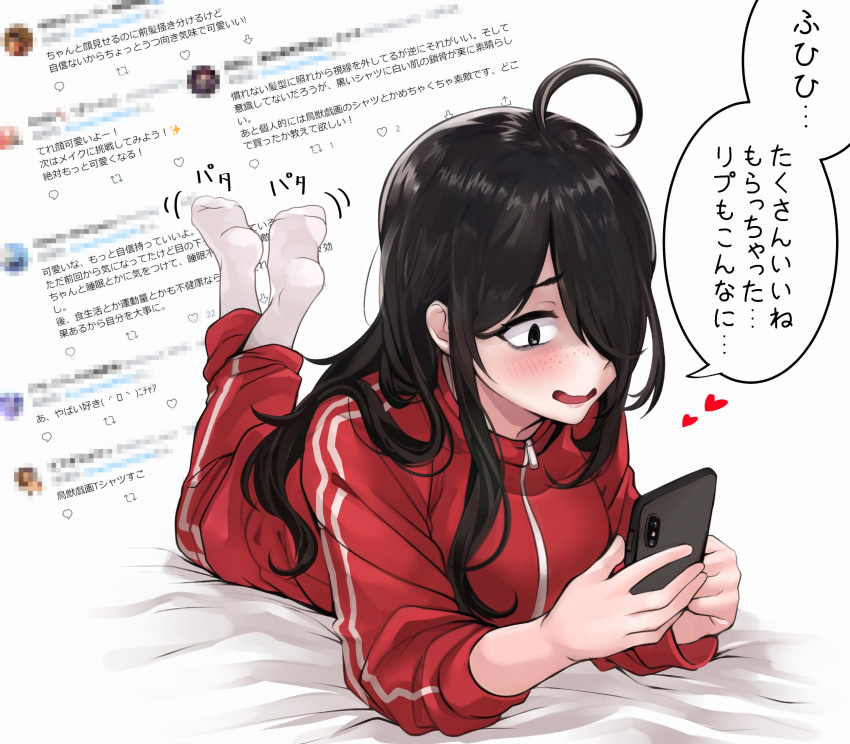1girl ahoge black_hair blush cellphone commentary_request feet_up freckles hair_over_one_eye heart highres holding holding_phone long_hair lying message_board on_stomach original phone red_track_suit shaded_face shashaki smartphone socks solo track_suit translation_request white_background
