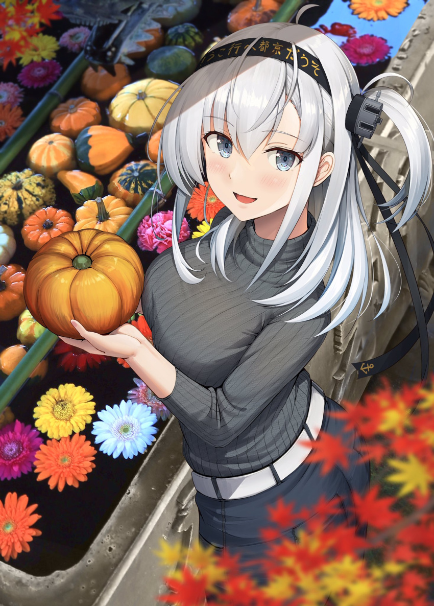 1girl autumn autumn_leaves black_headband black_pants blue_eyes blush breasts clothes_writing food grey_sweater hachimaki hair_between_eyes headband highres holding holding_food holding_vegetable ichikawa_feesu kantai_collection large_breasts long_hair long_sleeves one_side_up open_mouth pants photo_background pumpkin smile solo suzutsuki_(kancolle) sweater vegetable white_hair