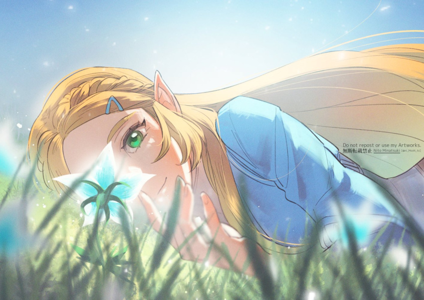 1girl artist_name bangs blonde_hair blue_shirt blurry blurry_foreground braid grass green_eyes hair_ornament hairclip long_hair long_sleeves lying nito_minatsuki on_stomach outdoors parted_bangs pointy_ears princess_zelda shirt sidelocks silent_princess smile solo the_legend_of_zelda the_legend_of_zelda:_breath_of_the_wild upper_body