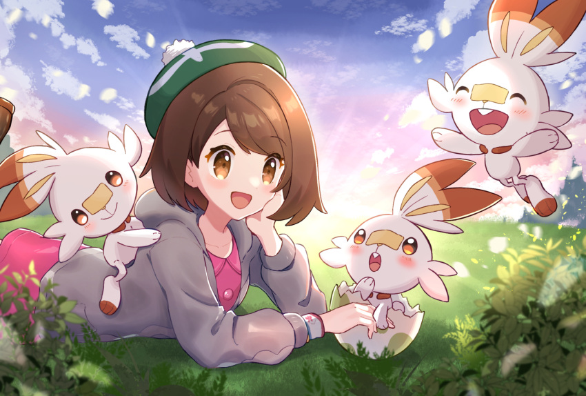 1girl :d bangs blush bob_cut brown_eyes brown_hair cardigan clouds collared_dress commentary_request day dress dynamax_band eggshell gloria_(pokemon) grass green_headwear grey_cardigan haru_(haruxxe) hat hatching highres hooded_cardigan lying on_stomach open_mouth outdoors pink_dress pokemon pokemon_(creature) pokemon_(game) pokemon_swsh scorbunny short_hair sky smile tam_o'_shanter tongue