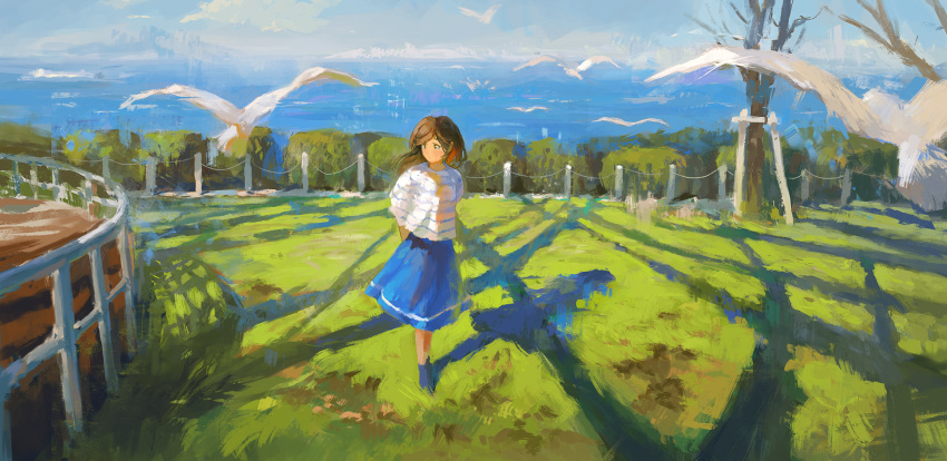 1girl animal arms_behind_back bird blue_skirt brown_eyes brown_hair day fence fjsmu flying grass highres ocean on_grass original outdoors scenery shadow shirt skirt solo striped striped_shirt tree water white_shirt