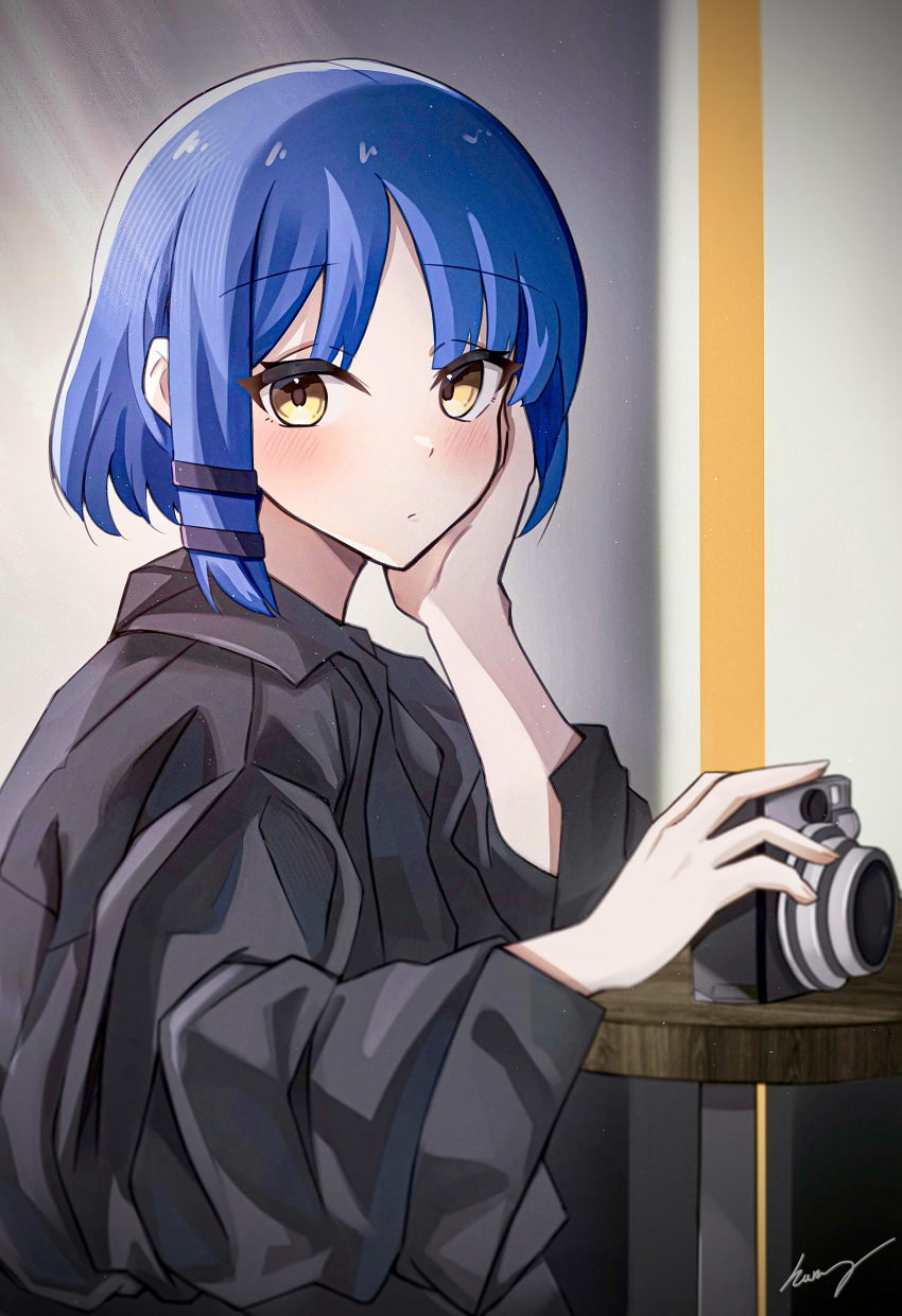 1girl absurdres bangs black_shirt blue_hair bocchi_the_rock! camera chinese_commentary closed_mouth collared_shirt commentary_request hair_ornament hairpin hand_on_own_cheek hand_on_own_face highres holding holding_camera humany indoors light_blush long_sleeves looking_at_viewer medium_hair oversized_clothes shirt signature solo table upper_body wide_sleeves yamada_ryou yellow_eyes