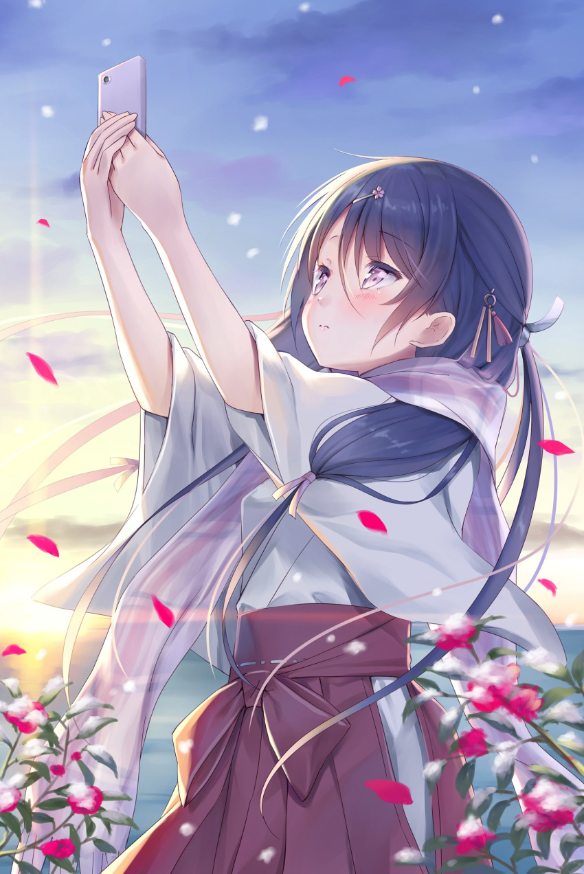 1girl absurdres blush cellphone closed_mouth commentary cowboy_shot day falling_petals from_side hair_between_eyes hair_ornament hairclip hakama hakama_skirt half_updo hands_up highres holding holding_phone japanese_clothes kimono long_hair looking_at_phone low_twintails miko na-ga original outdoors petals phone purple_hair red_hakama sidelocks skirt smartphone snowing solo sun twintails violet_eyes white_kimono wide_sleeves