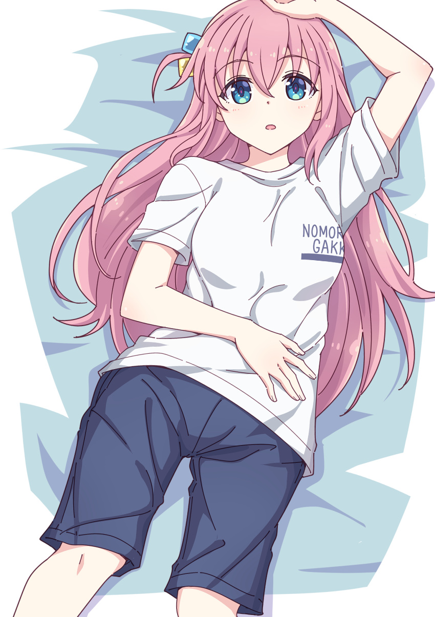 1girl arm_up bangs bed_sheet black_shorts blue_eyes blush bocchi_the_rock! breasts clothes_writing cube_hair_ornament e20 feet_out_of_frame gotou_hitori grey_shirt hair_between_eyes hair_ornament highres long_hair lying medium_breasts on_back one_side_up parted_lips pink_hair shirt short_sleeves shorts solo very_long_hair
