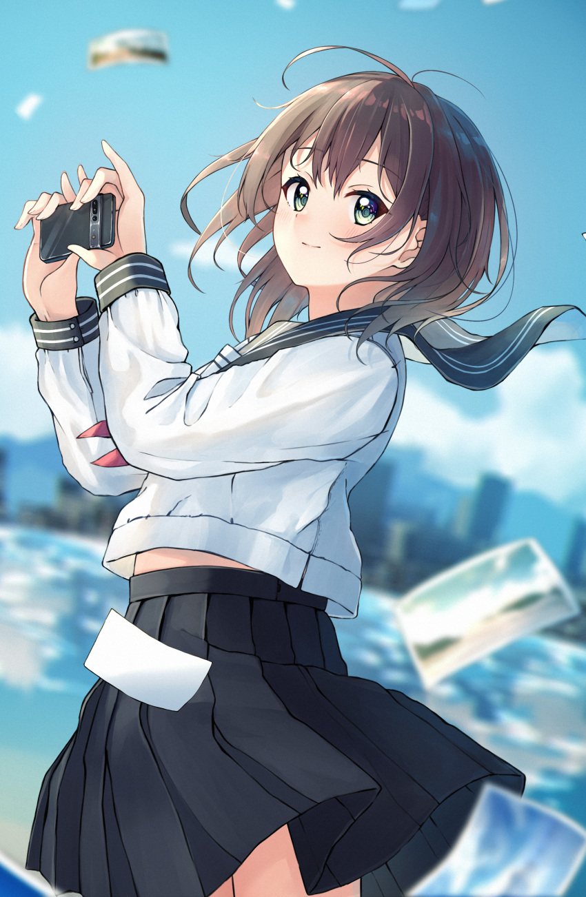 1girl absurdres bangs black_sailor_collar black_skirt blue_sky blurry blurry_background blush brown_hair cellphone closed_mouth commentary_request day depth_of_field enuni green_eyes hair_between_eyes hands_up highres holding holding_phone long_sleeves neckerchief official_art original outdoors phone photo_(object) pleated_skirt red_neckerchief sailor_collar school_uniform serafuku shirt skirt sky skyline smile solo white_shirt