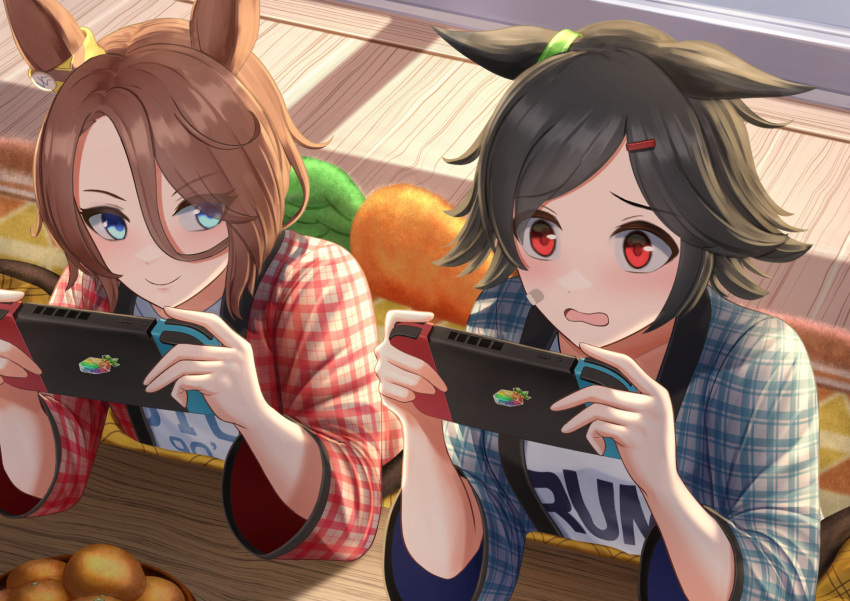 2girls animal_ears bandaid bandaid_on_face black_hair blue_eyes brown_hair clothes_writing commentary hair_between_eyes hair_ornament hairclip handheld_game_console highres holding holding_handheld_game_console horse_ears horse_girl itsuki_toiro jewel_(umamusume) kotatsu multiple_girls narita_taishin_(umamusume) nintendo_switch red_eyes shirt short_hair table umamusume winning_ticket_(umamusume)