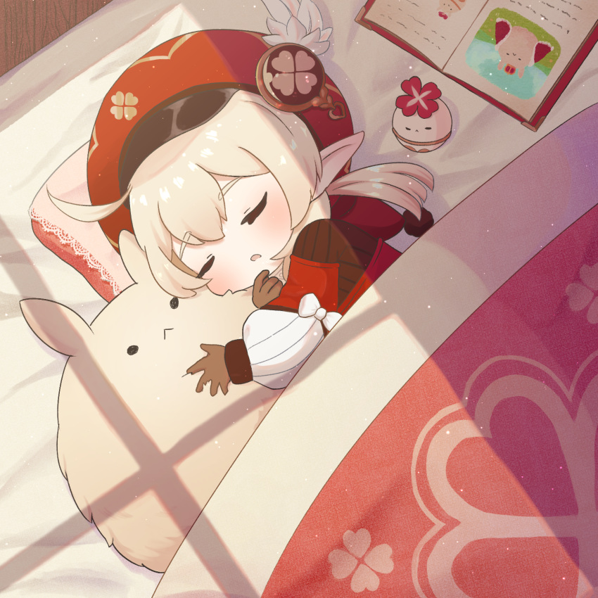 1girl ahoge bangs bed bed_sheet blanket book brown_gloves brown_scarf cabbie_hat clover_print coat commentary_request dodoco_(genshin_impact) doll_hug genshin_impact gloves hair_between_eyes hat hat_feather hat_ornament highres hooded_coat jumpy_dumpty klee_(genshin_impact) long_hair long_sleeves low_twintails lying nami_harakamiaka object_hug on_side parted_lips pillow pointy_ears red_coat red_headwear scarf sidelocks sleeping solo stuffed_animal stuffed_toy sunlight twintails