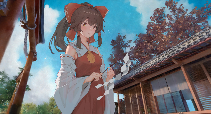 1girl absurdres ascot bangs blush bow brown_eyes brown_hair clouds day detached_sleeves eyebrows_hidden_by_hair from_below gohei hair_between_eyes hair_bow hair_tubes hakurei_reimu highres holding holding_stick nontraditional_miko open_mouth outdoors red_bow ribbon-trimmed_sleeves ribbon_trim shrine sky solo stick torii touhou tree user_rvve7522 wide_sleeves yellow_ascot