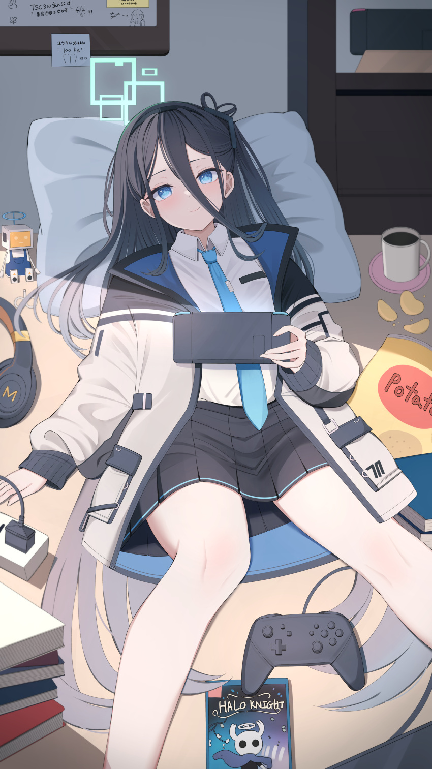 1girl absurdres aris_(blue_archive) black_hair blue_archive blue_eyes blue_necktie controller game_controller hair_between_eyes halo highres hiyayo25 jacket long_hair looking_at_viewer lying necktie on_back on_table pillow skirt solo table