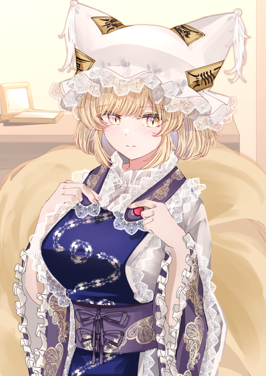 1girl animal_ears blonde_hair blush breasts closed_mouth dress fox_ears fox_tail frilled_sleeves frills hat highres indoors large_breasts long_sleeves mob_cap multiple_tails obi sarasadou_dan sash short_hair solo tabard tail touhou white_dress white_headwear wide_sleeves yakumo_ran yellow_eyes