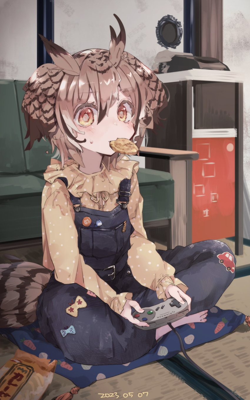 1girl alternate_costume bird_tail blouse blue_overalls brown_eyes brown_hair contemporary cookie couch eurasian_eagle_owl_(kemono_friends) food full_body hair_between_eyes highres indoors japari_symbol kemono_friends long_sleeves looking_at_viewer medium_hair mouth_hold multicolored_hair nanana_(nanana_iz) on_floor overalls shirt sitting solo super_famicom_gamepad tail tatami