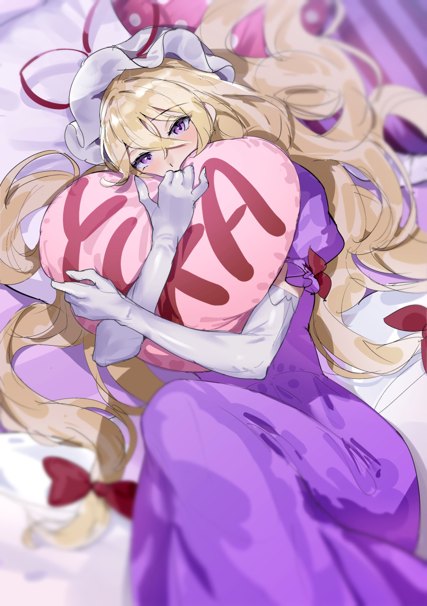 1girl absurdres blonde_hair blurry character_name commentary depth_of_field dress elbow_gloves english_commentary gloves gunnjou_yosio heart heart_pillow highres long_hair looking_at_viewer low-tied_long_hair object_hug on_bed pillow pillow_hug pink_eyes purple_dress short_sleeves solo touhou white_gloves yakumo_yukari